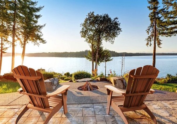 The Best Adirondack Chairs Option placed looking at a lake and a small outdoor firepit