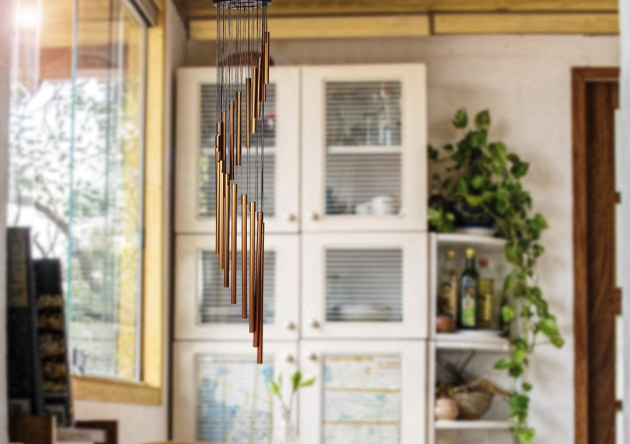 The best wind chime option hanging in the foreground with a wooden hutch, dishes, and plants in the background