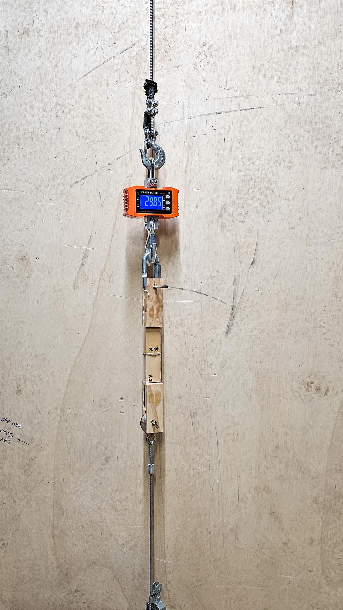 The Best Construction Adhesive crane scale and glued boards under pulling pressure
