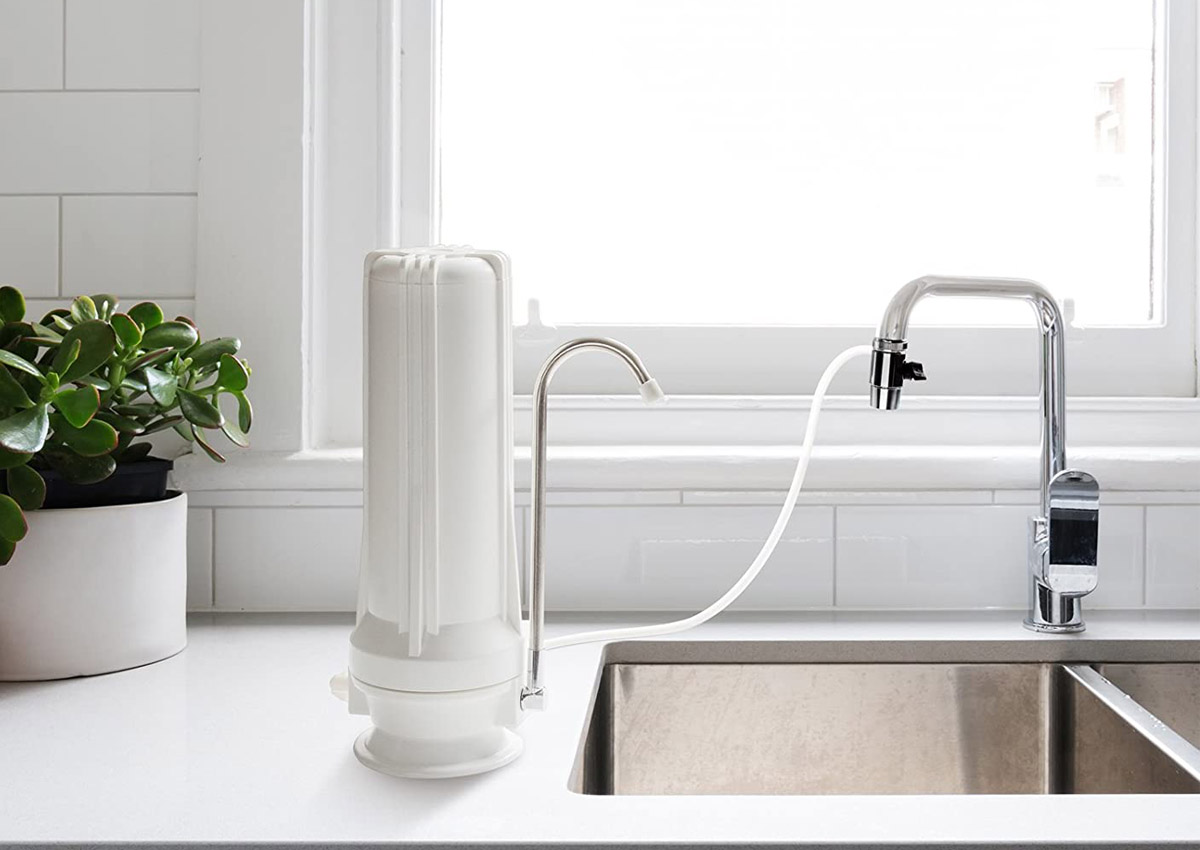 The Best Countertop Water Filter Option placed next to a kitchen sink and attached to its faucet