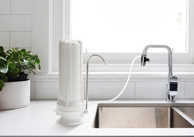 The Best Countertop Water Filter Option placed next to a kitchen sink and attached to its faucet