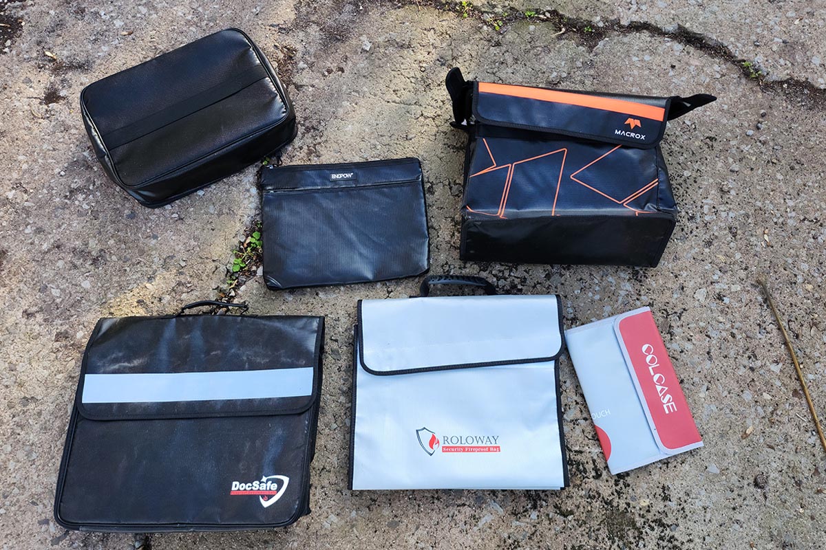 A group of the best fireproof document bags together on a rocky, sandy surface before testing.