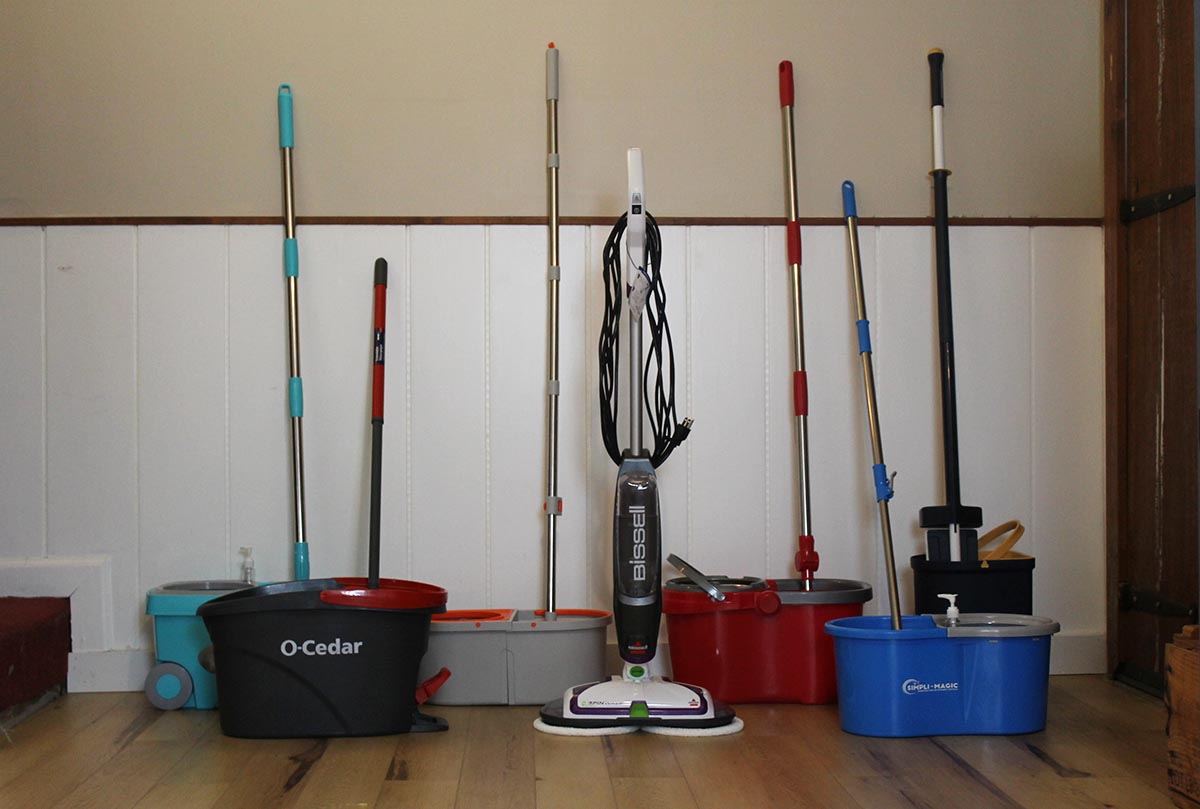 A group of the best spin mop options together against a wall