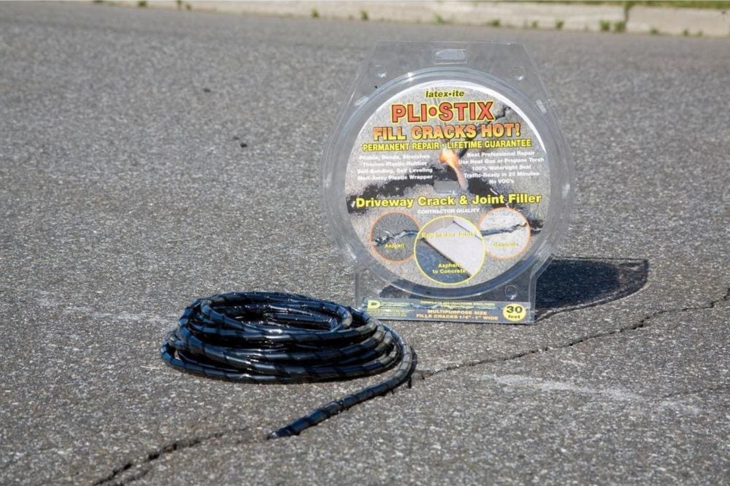 The Best Asphalt Driveway Crack Filler Option sits on the ground next to a large crack