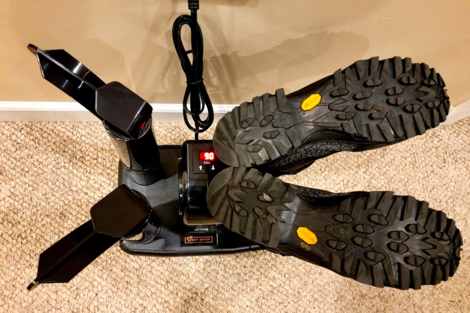 The best boot dryer option drying a pair of boots while plugged in in what appears to be a hallway.