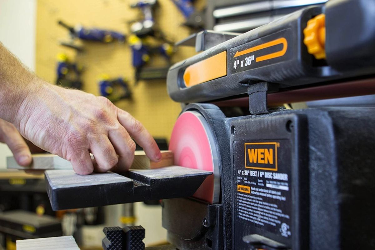 A person using the best belt sander option to sand a small block of wood