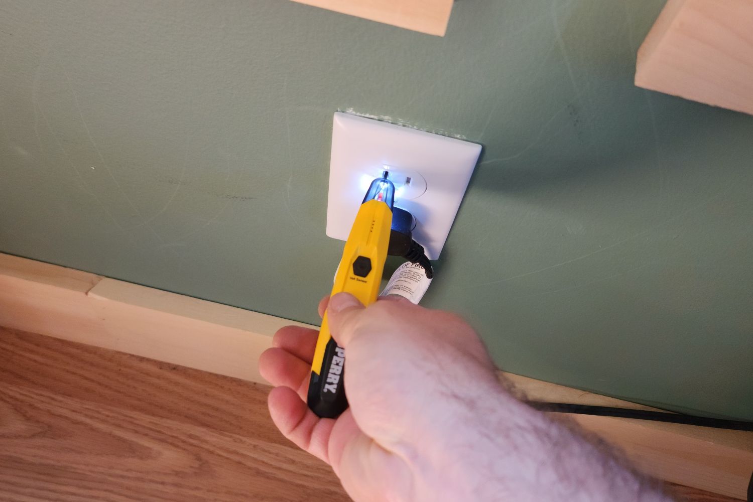 A person using the Sperry Instruments STK001 Non-Contact Voltage Tester to test an electrical outlet.