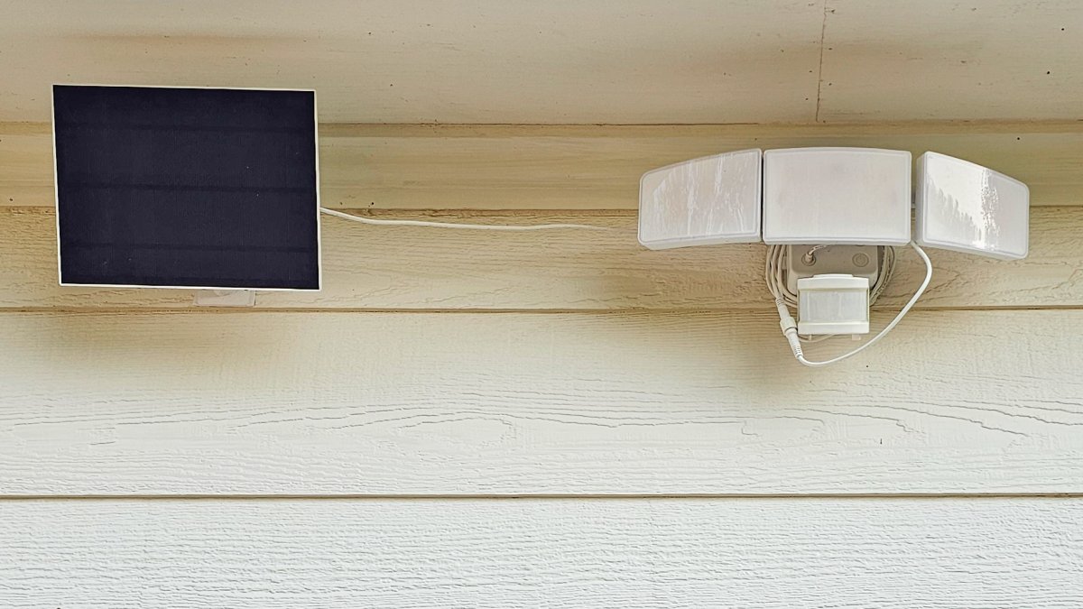 GE solar flood light mounted on home with solar panel