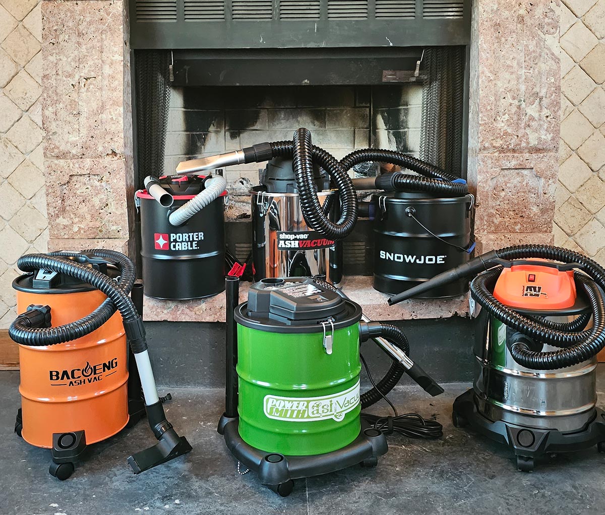 A group of the best tested ash vacuums placed together in front of an indoor fireplace.