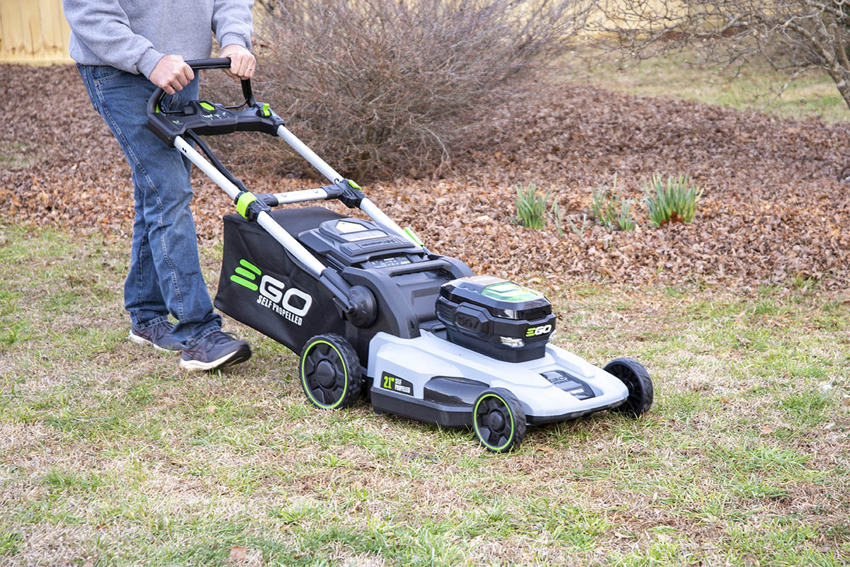 A person using the best electric mower to mow a yard