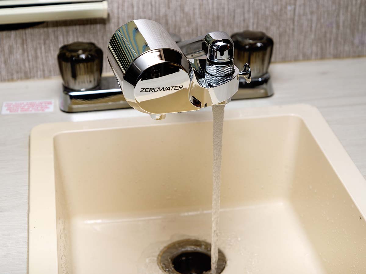 Chrome water faucet filter being used at sink