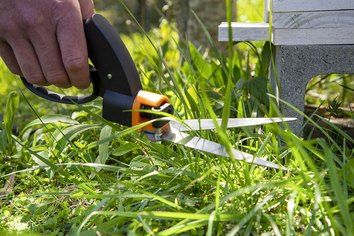 Person cutting grass with Fiskars grass shears