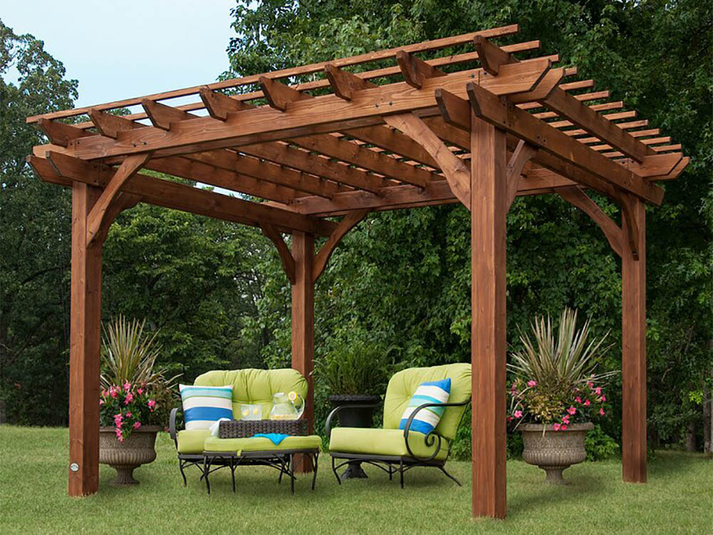 The best pergola kit option assembled in a yard with chairs, a table, and plants beneath it