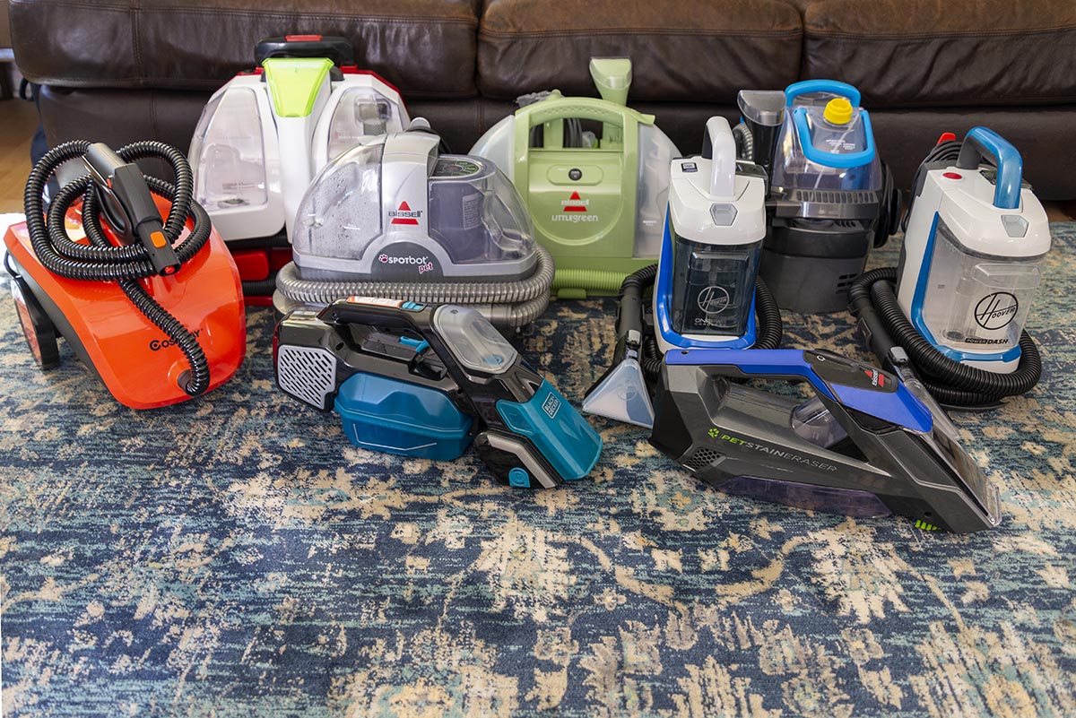 A group of the best portable carpet cleaners sitting together on a patterned rug.