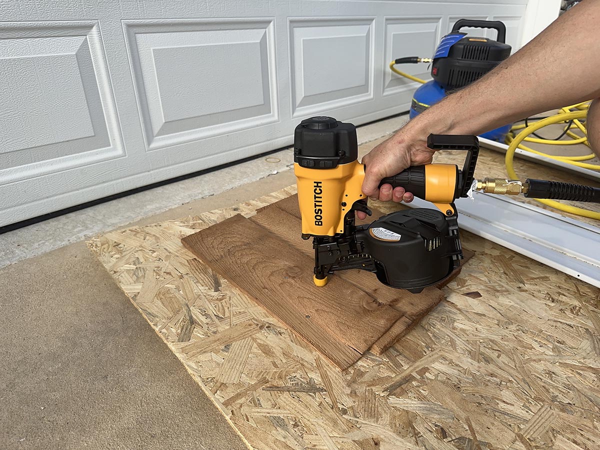 Person using Bostitch siding nailer on cedar siding