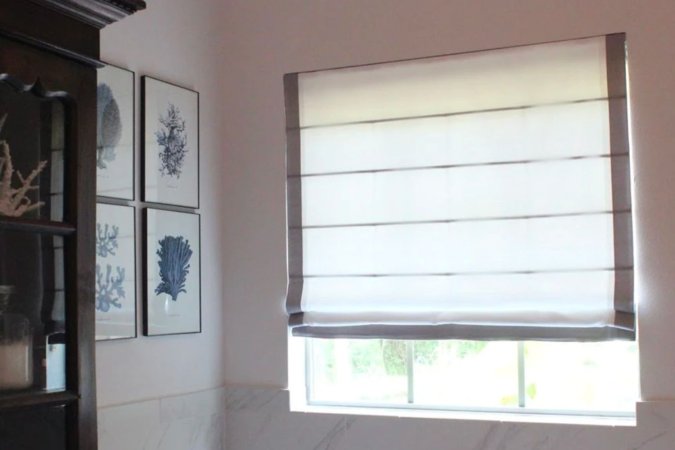 The best Roman shades option installed in a living room and partially closed to block a sunny day