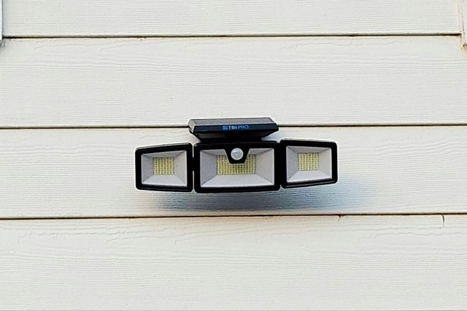 The best solar floodlight option installed on the siding of a house.