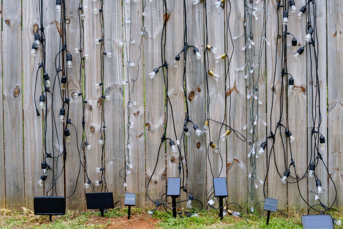 The Best Solar String Lights Options strung vertically on a wooden fence