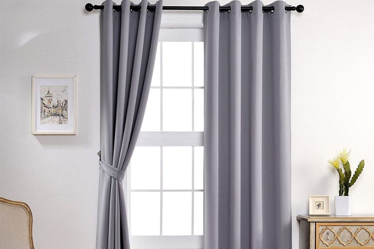 The best sound proof curtains option in a bright and clean living room with one side tied back to reveal a windwo