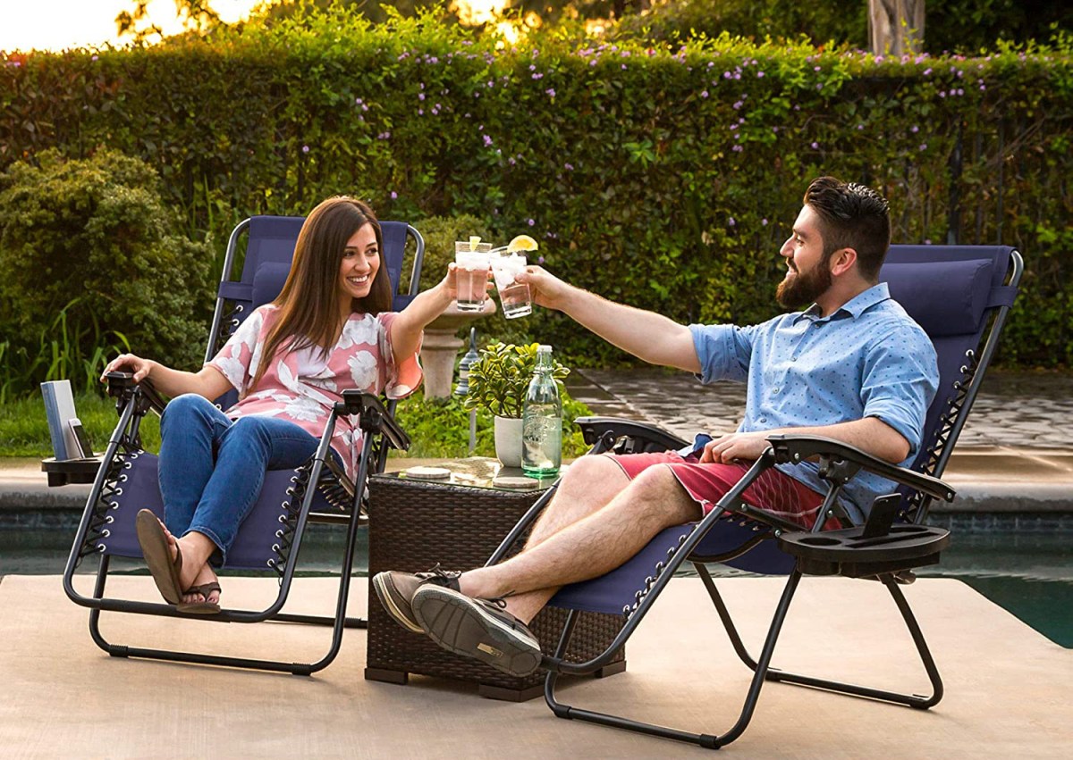 A couple clinking glasses while reclining comfortably in the best patio chairs option