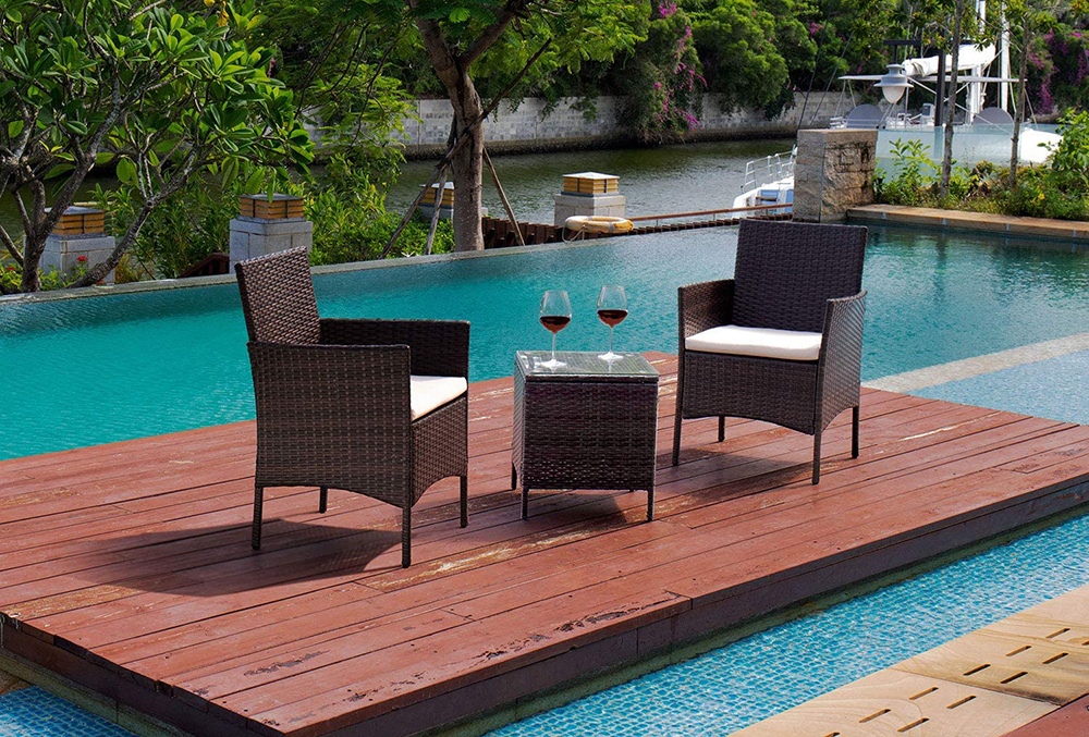 The best patio chairs option sitting with a side table and two glasses of wine on a floating deck