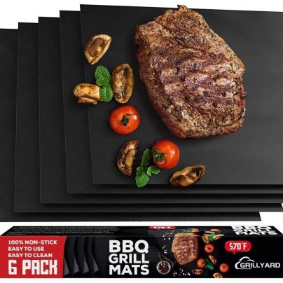The Grillyard Set of 6 Nonstick Reusable Grill Mats with grilled vegetables and steak on them.