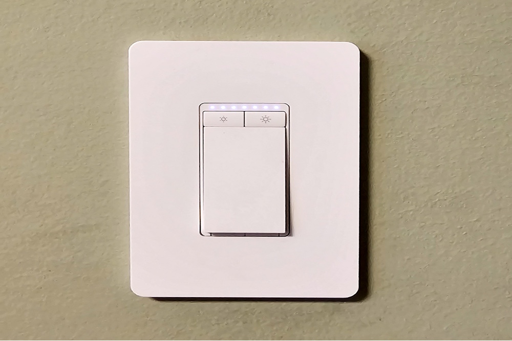 The Kasa Smart Wi-Fi Dimmer Light Switch installed on a greige wall.