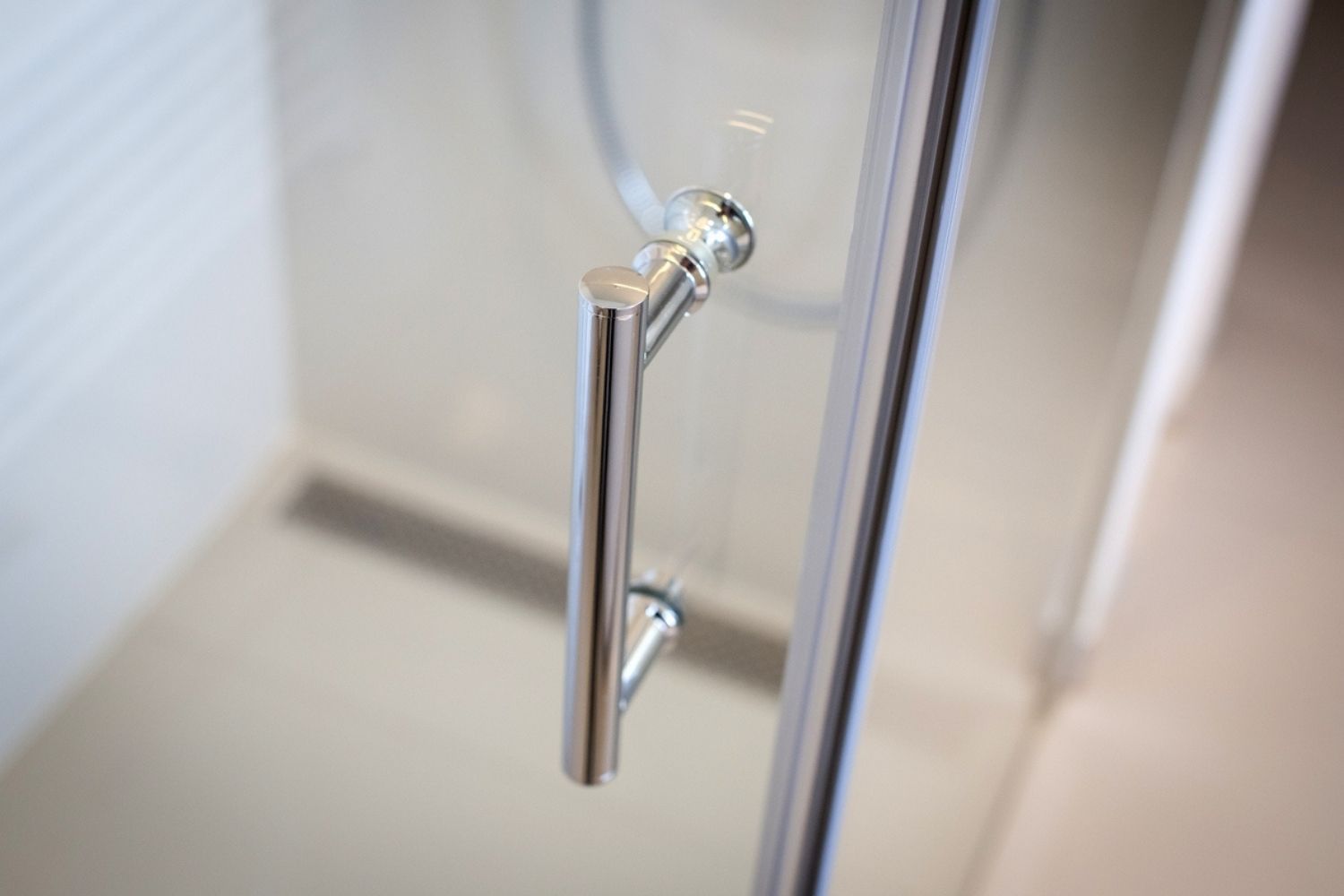 A close-up of the shower door handle on the best shower door option