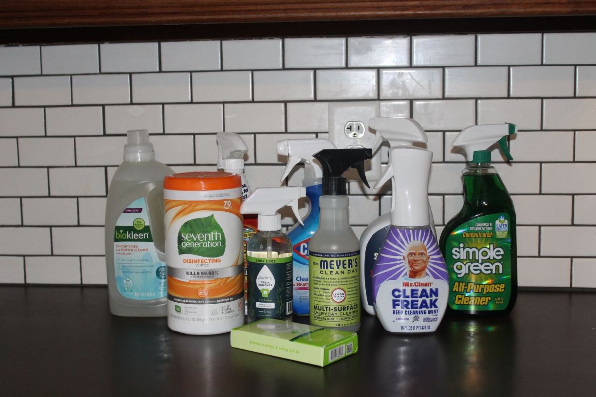 Nine all-purpose cleaners on a countertop in front of white subway tile