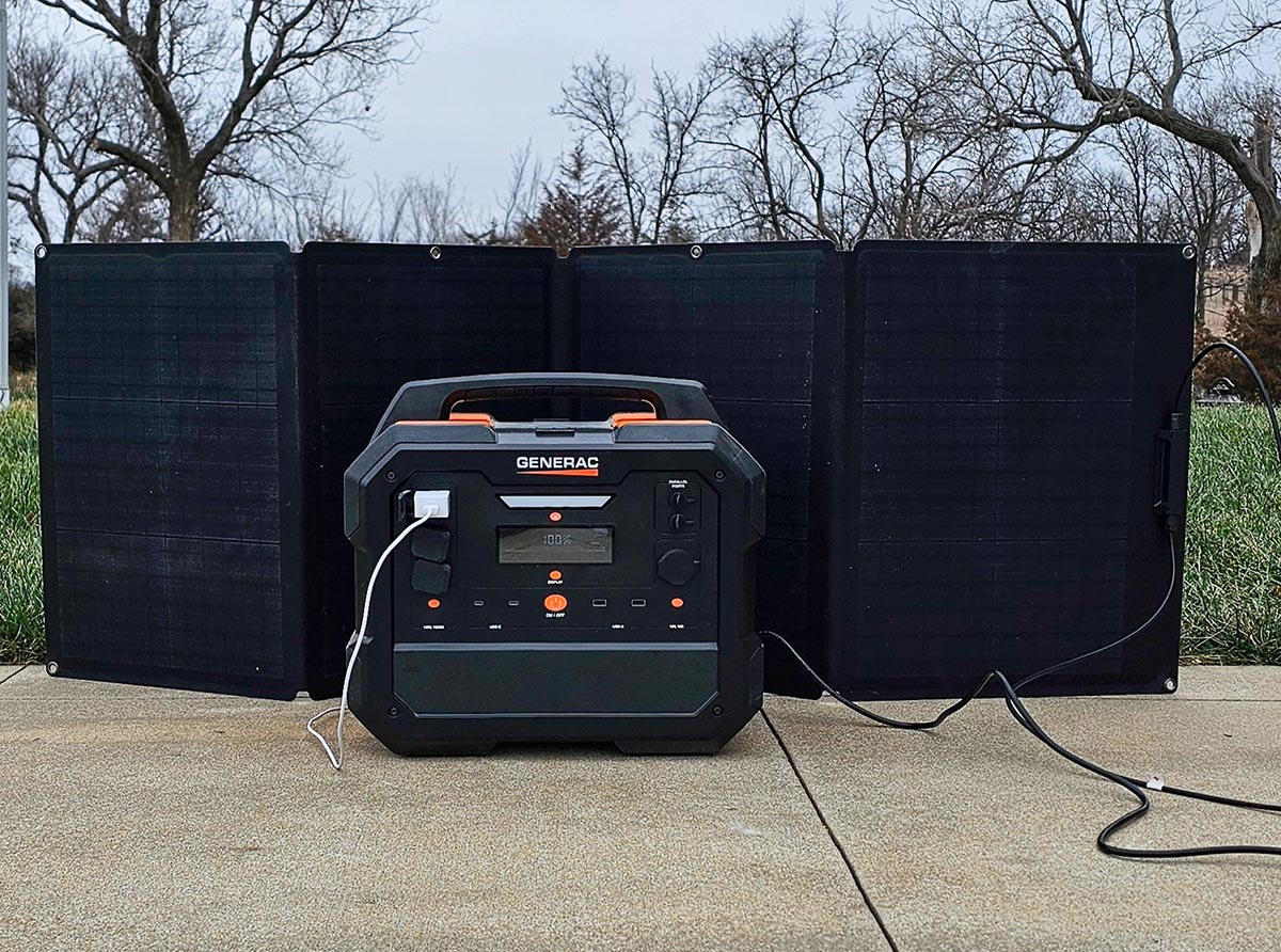 The Generac GB2000 Portable Power Station set up outside during testing with a solar panel behind it.