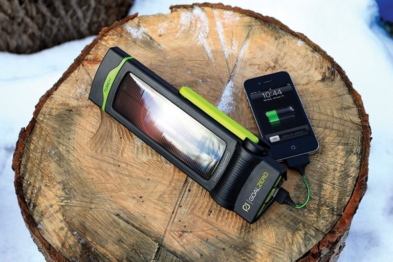 One of the Best Hand Crank Flashlights lit up atop a tree stump