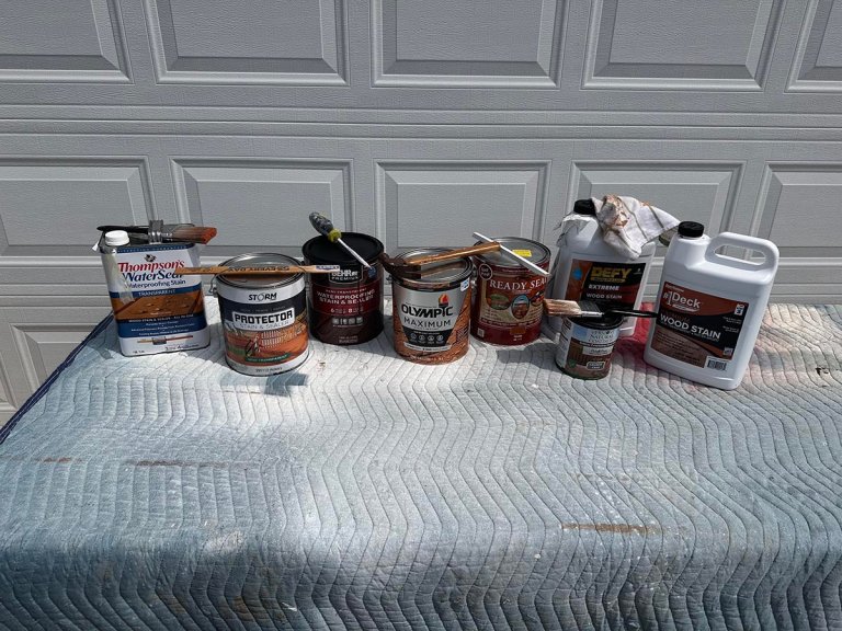 A group of the best exterior wood stains in front of a garage door before testing.