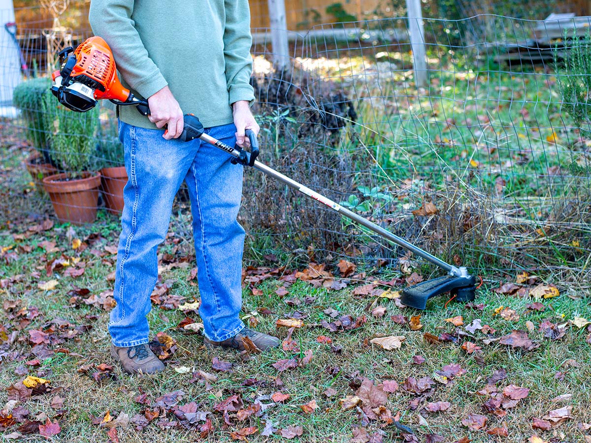 A man using the best gas string trimmer option in his yard