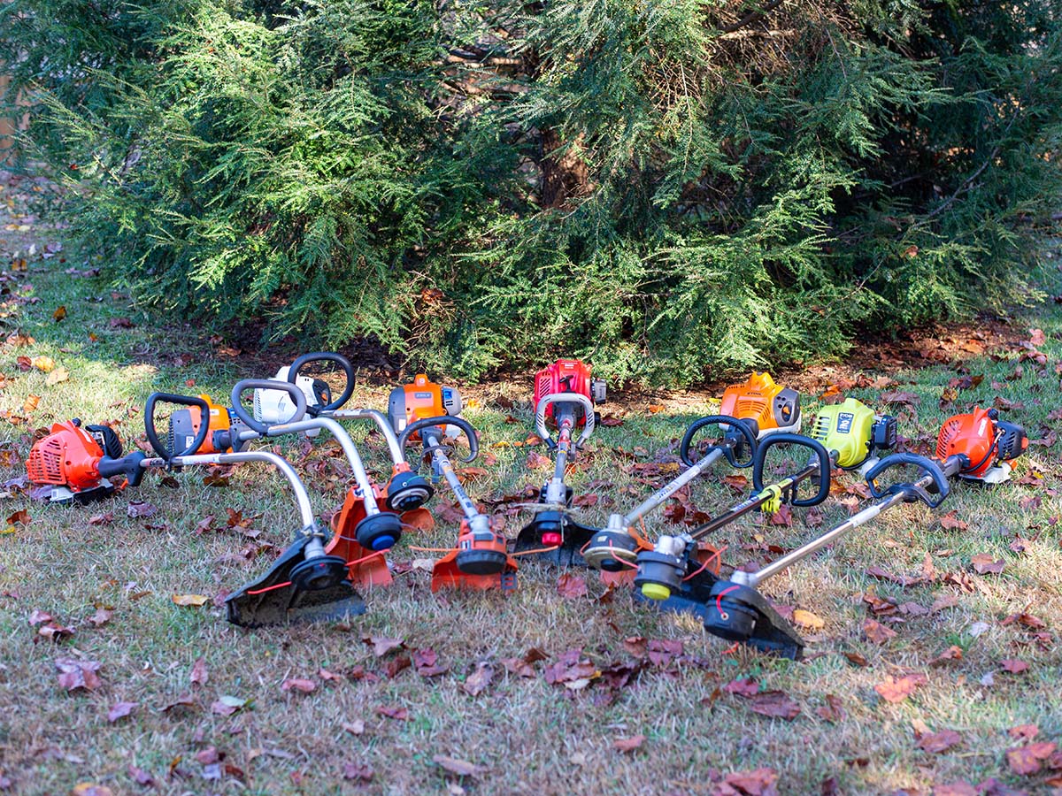 A group of the best gas string trimmer options together outside on the ground