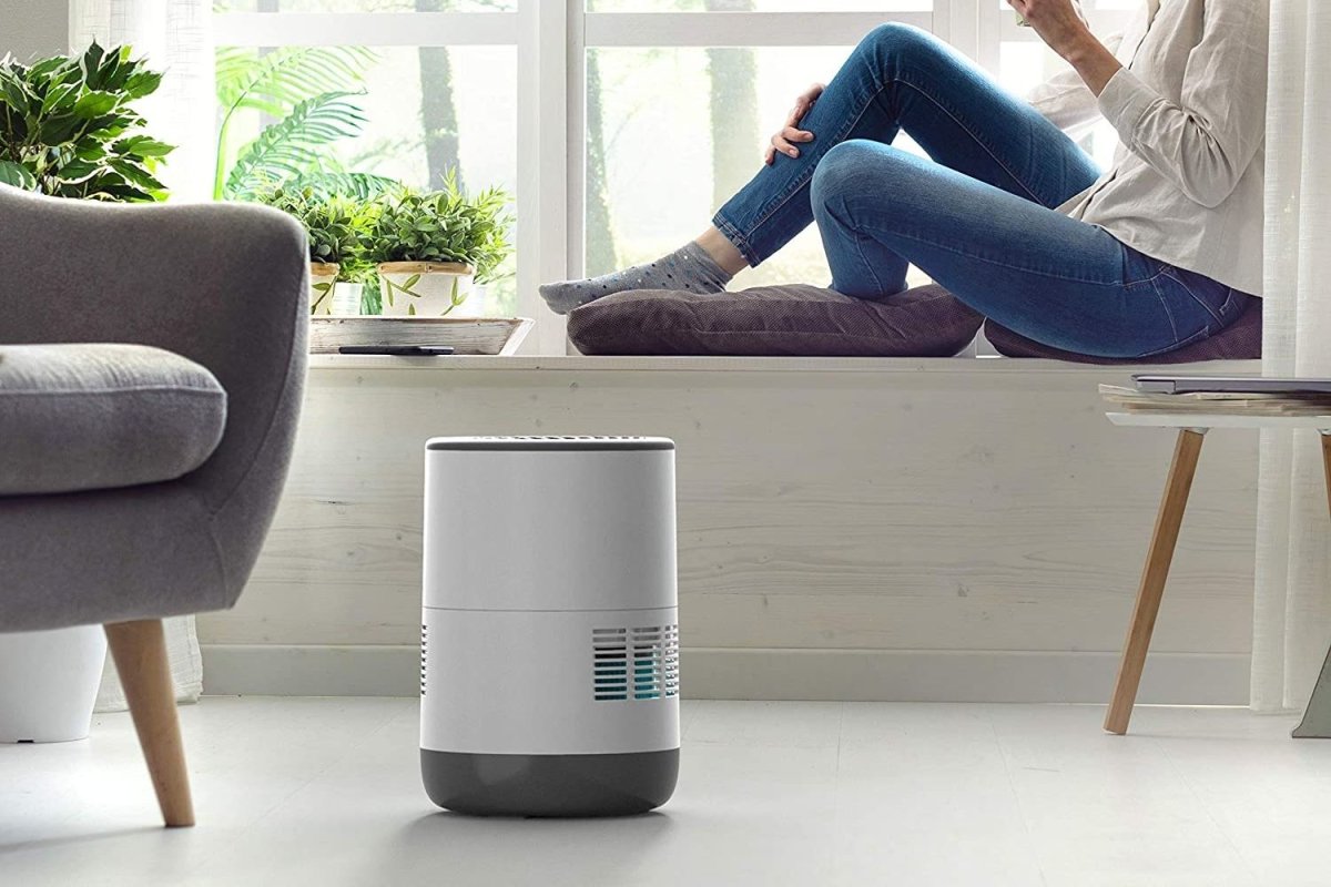 The best evaporative humidifier set up in a living room while a person relaxes in the background