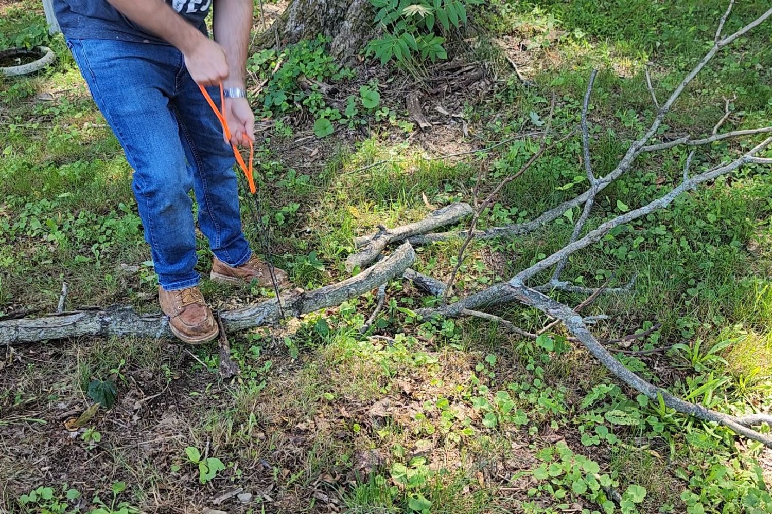 A person using the best pocket chainsaw option to cut a tree branch in half