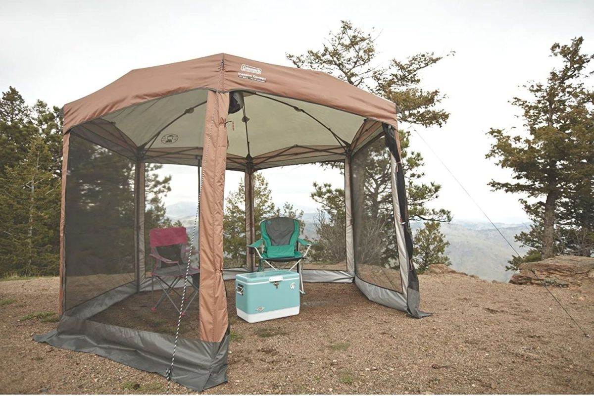 The Best Screen Tent Option set up on a rocky overlook with camping chairs and a cooler inside