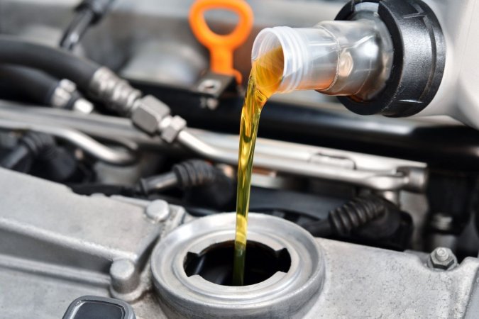 A close-up of the best oil for snow blower being added to a snow blower