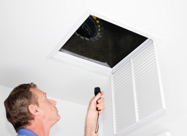home inspector looking inside vent