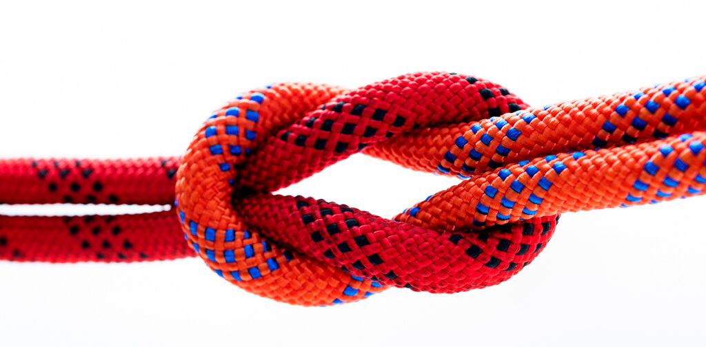 Rope with reef (or square) knot isolated on white background