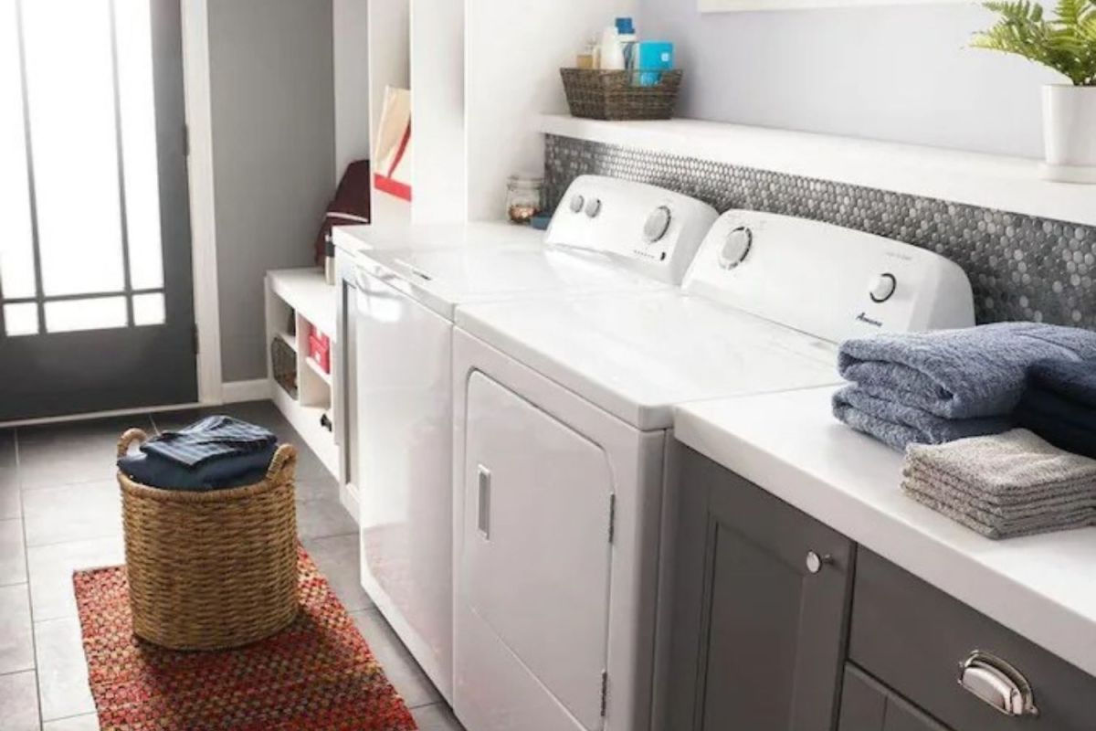 The best top-loading washing machine option next to a dryer and folding station in a tidy laundry room