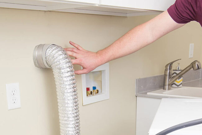 A person installing a dtyer vent hose for tight spaces