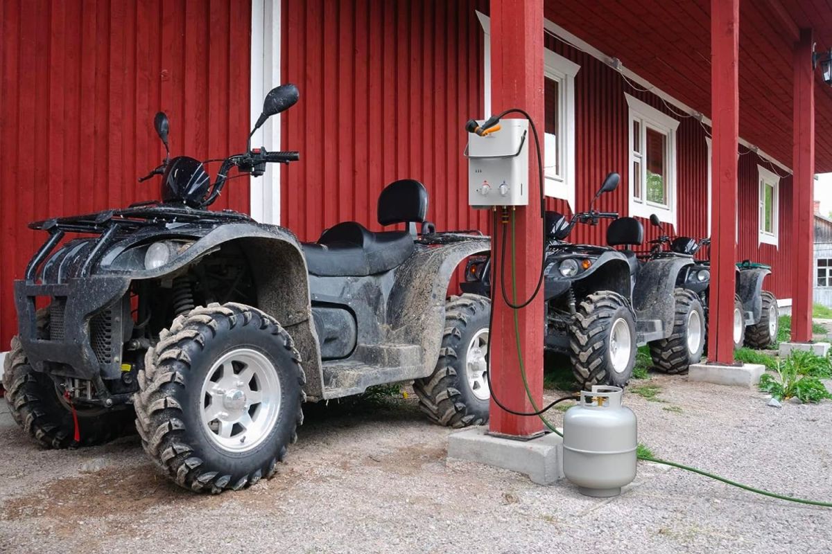 The best propane tankless water heater option installed on a pole next to several ATVs outside a barn