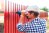 A worker installs a red fence.