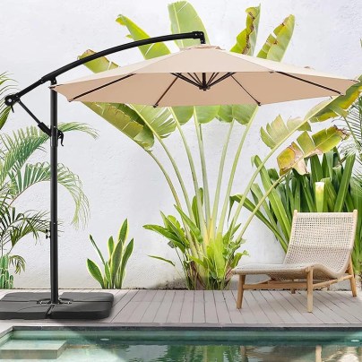 Bluu Banyan Pro Offset Umbrella next to a lounger and pool with some plants