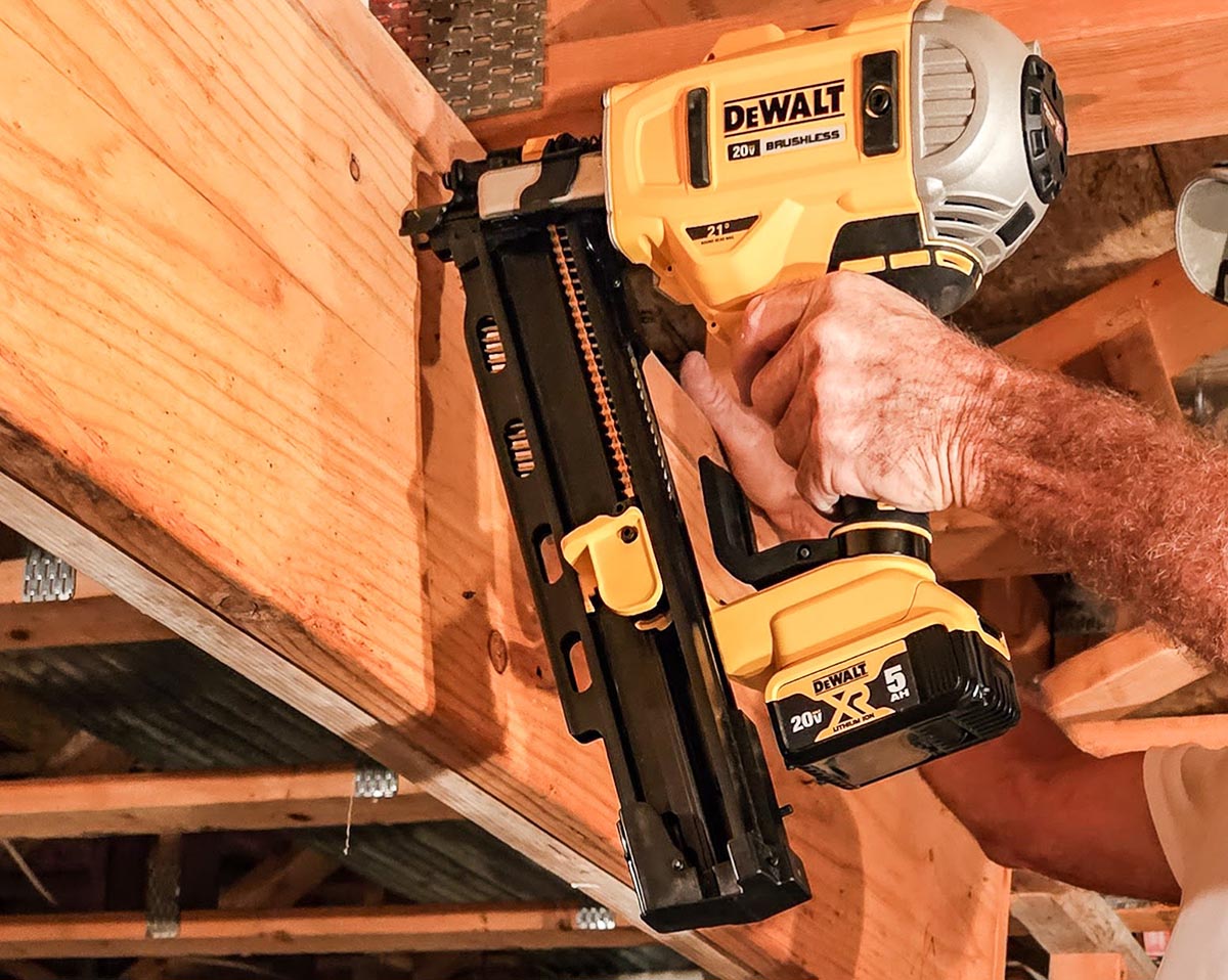 A person using the best cordless framing nailer option to install a header