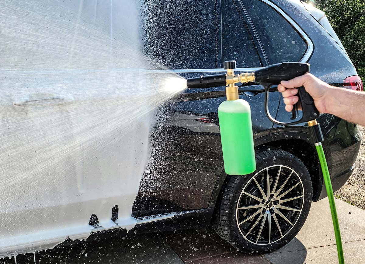 Person cleaning black SUV with Willcrew hose end sprayer