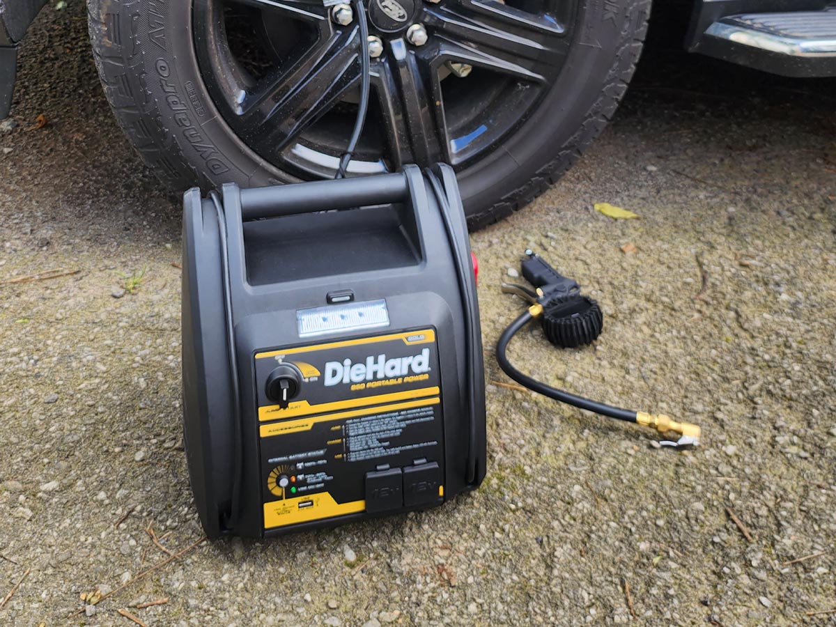 The best jump starter with air compressor option on the ground next to a car tire
