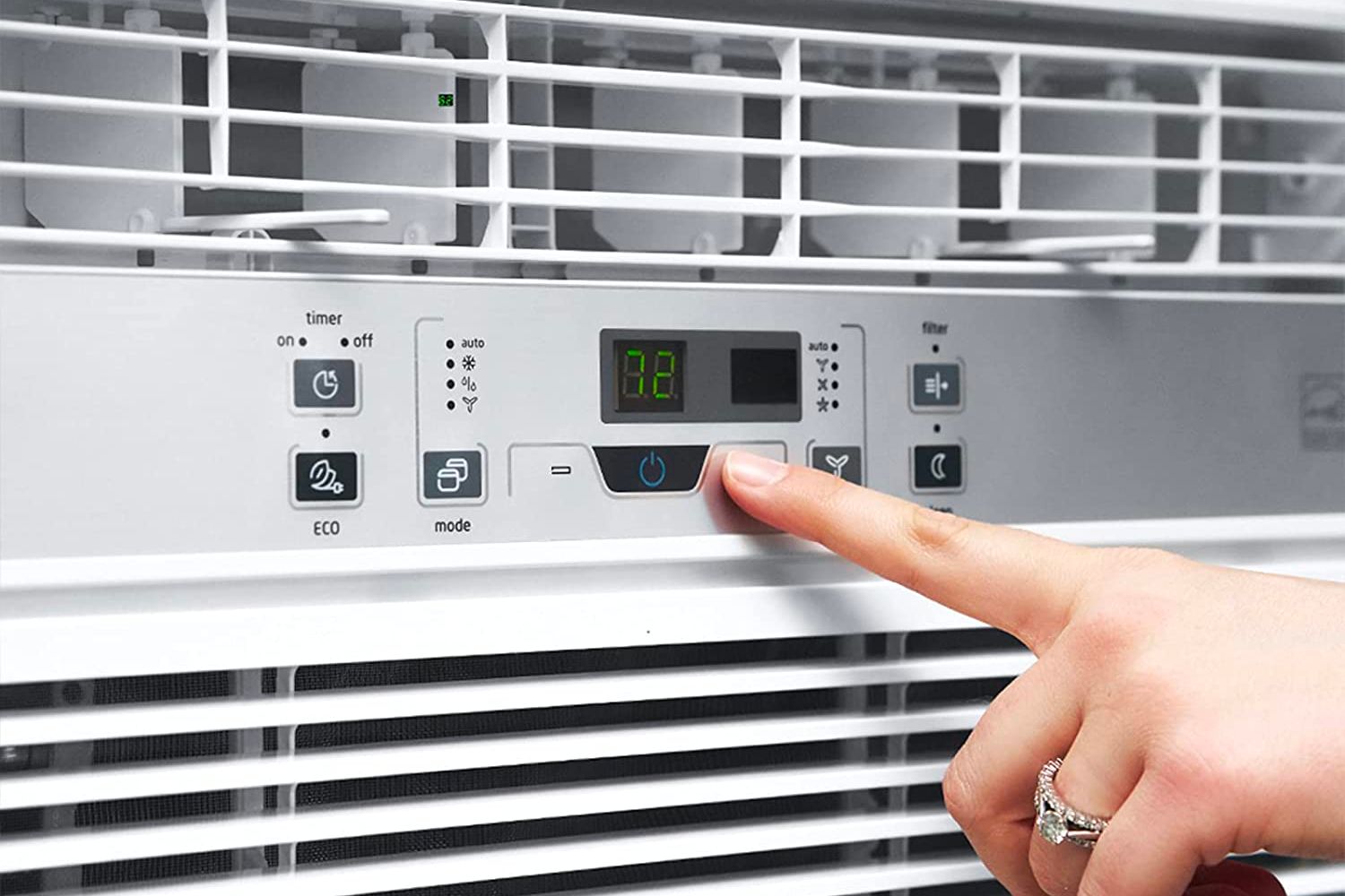 Woman's finger pointing to digital display on the best 10000 btu window air conditioner