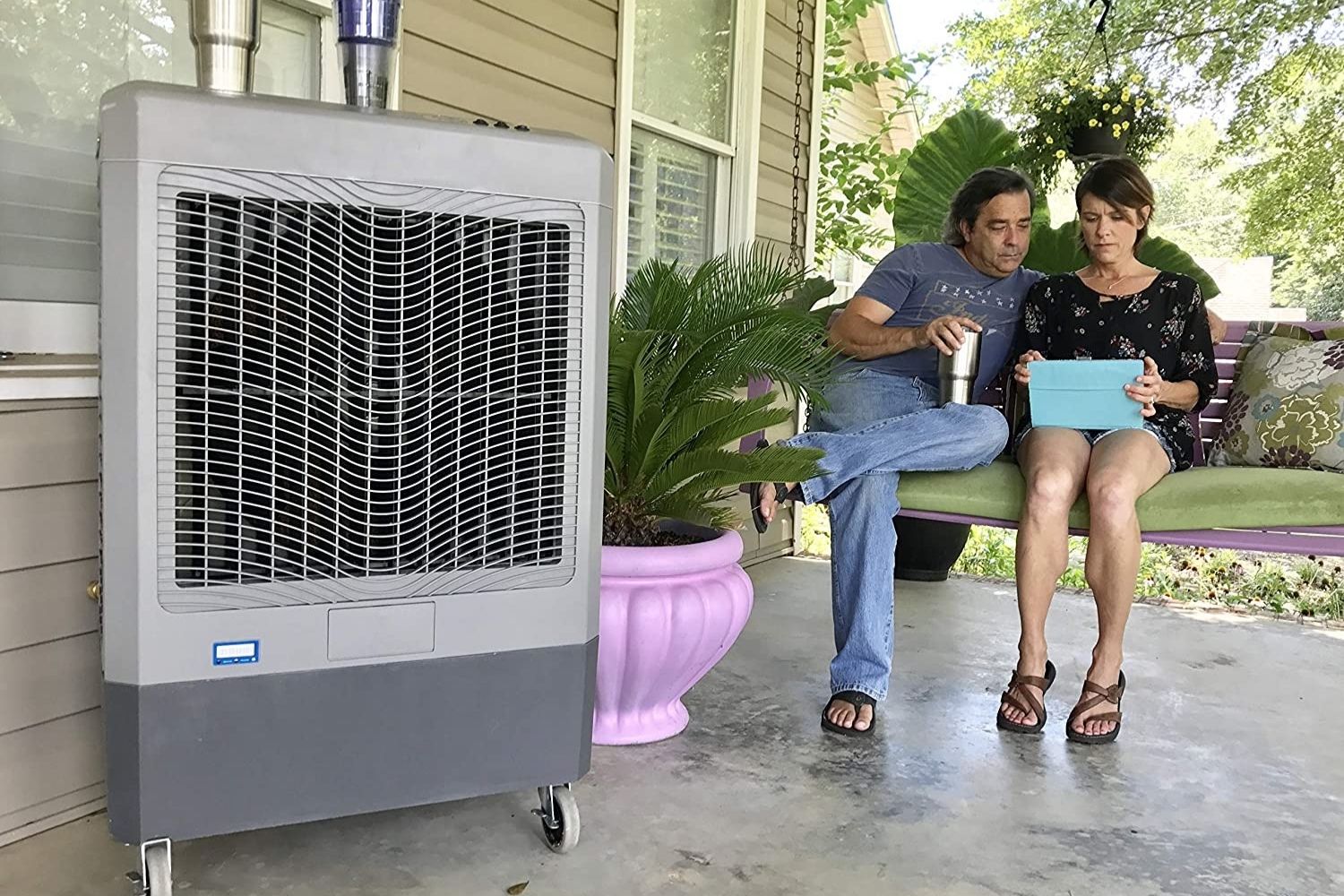 The best evaporative air cooler option on a porch near two people sitting on a porch swing